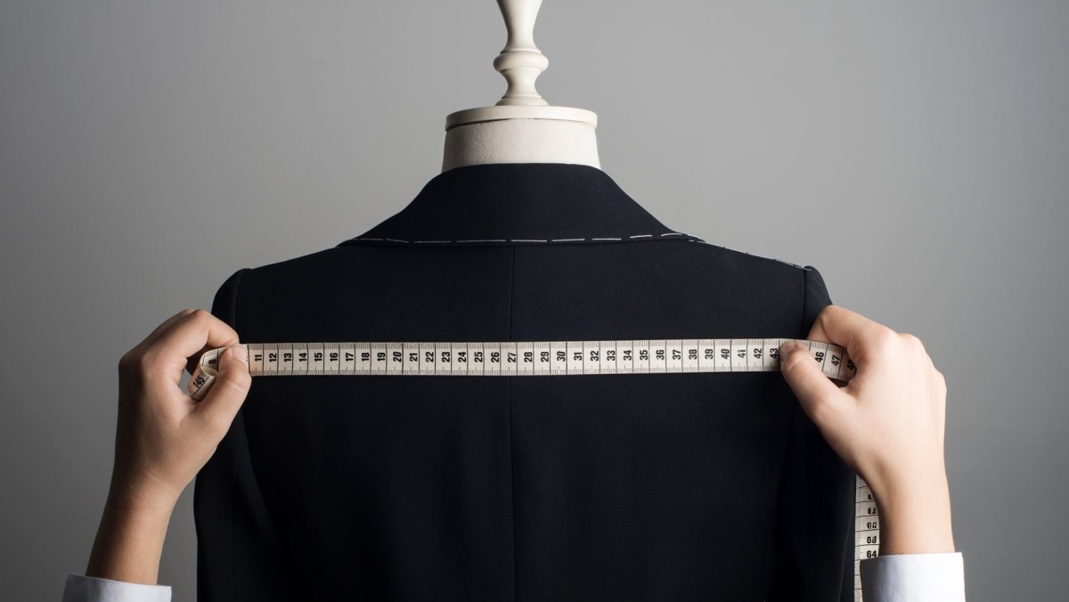 Abito sartoriale, esempio di branding aziendale tramite cura dei dettagli. Abito sartoriale appeso a un manichino come un Branding aziendale